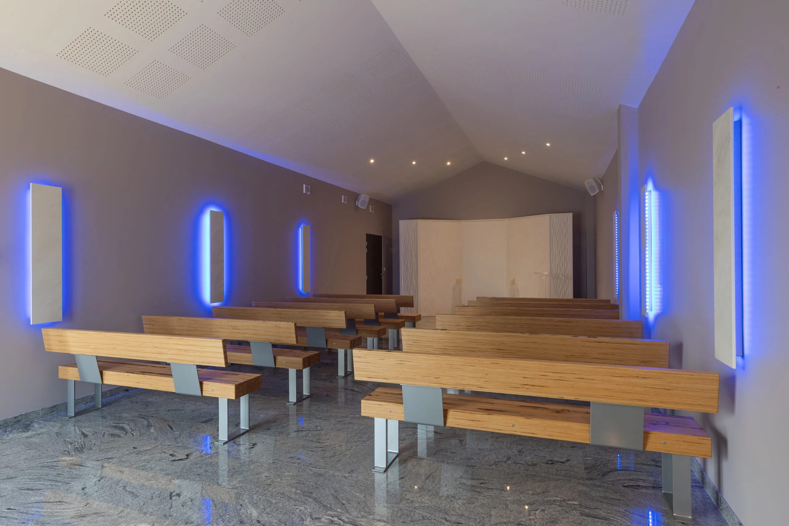 Grande salle de cérémonie moderne des Pompes Funèbres Gattot avec éclairage et bancs en bois